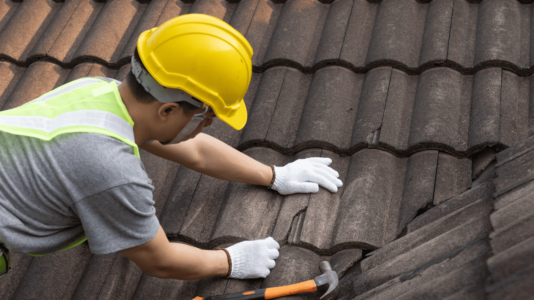 Roofer inspecting and maintaining a home’s roof to prevent damage. Discover how seasonal maintenance can extend the lifespan of your Asheville roof.