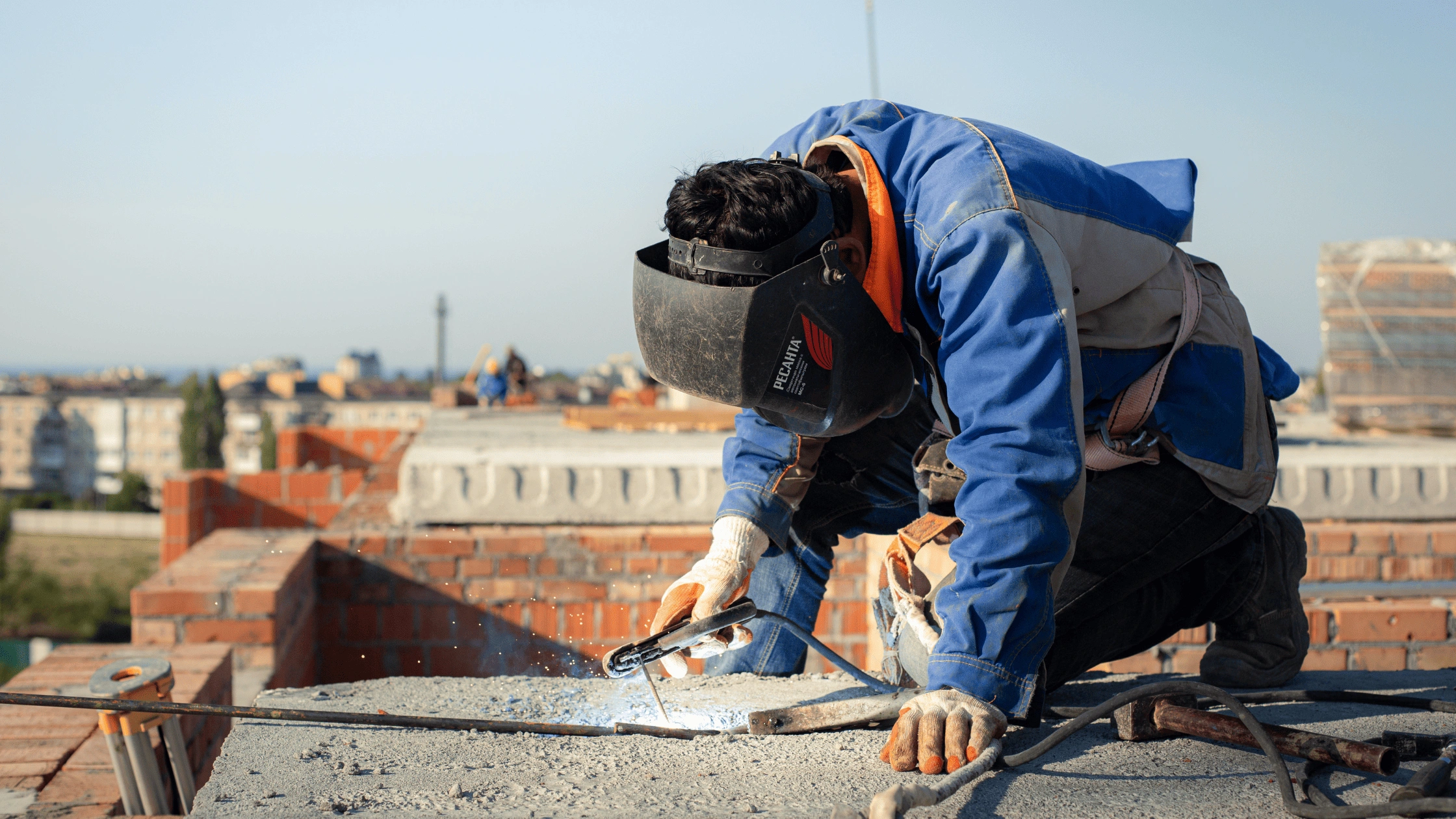 Commercial roofer welding and securing roofing materials on a flat rooftop in Asheville, NC, demonstrating professional commercial roofing installation.